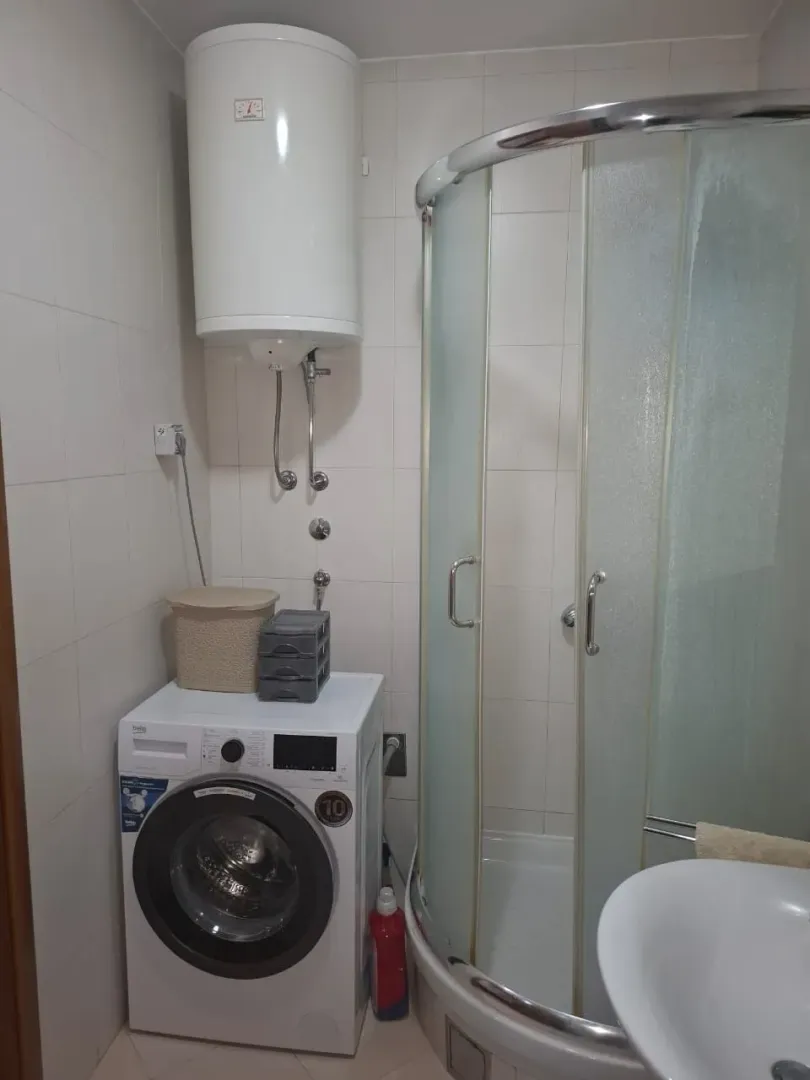 Bathroom with a shower cabin, water heater and washing machine.