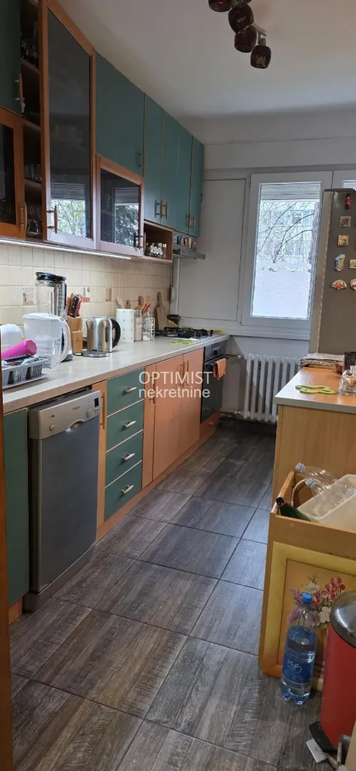 Small kitchen with wooden and green cabinets and built-in appliances.