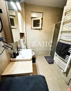 Smaller bathroom with a sink, shower cabin, and built-in fixtures. - image 5