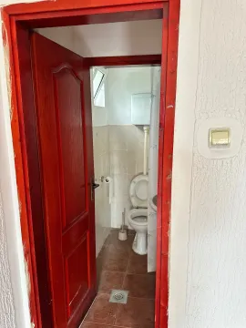 View of the bathroom through an open red wooden door frame. - image 5