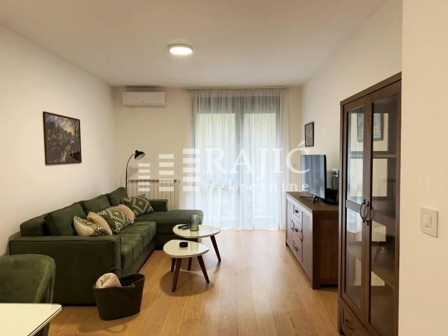 Furnished living room with a sofa, coffee tables, and wooden furniture.