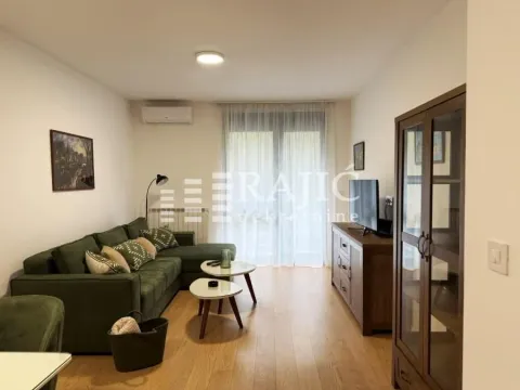 Furnished living room with a sofa, coffee tables, and wooden furniture. - image 3