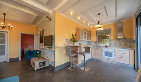 Moderna kuhinja sa šankom i trpezarijskim dijelom povezana sa dnevnim boravkom. - image 33