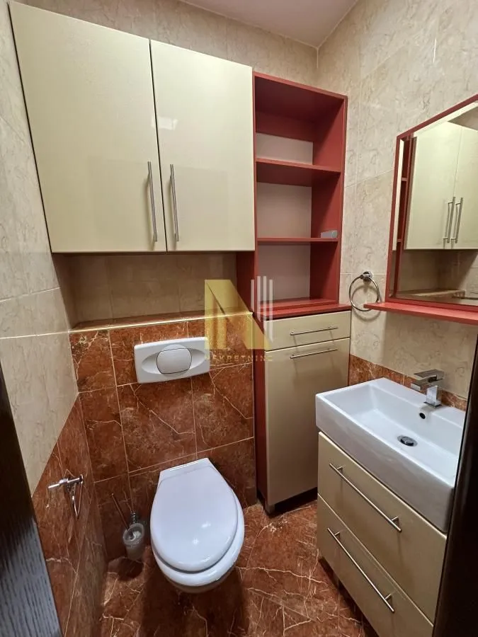 Kupatilo opremljeno WC šoljom, umivaonikom i ugradnim elementima.