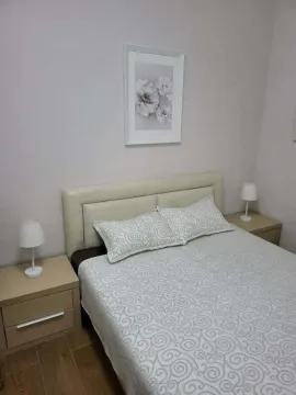 Namještena spavaća soba sa bračnim krevetom, noćnim stočićima i umjetničkom slikom na zidu. - image 8