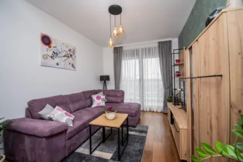 Living room with a sofa, coffee table and wooden furniture. - image 2
