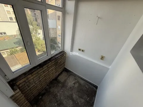 Zastakljeni balkon sa pogledom na okolne zgrade i dvorište. - image 10