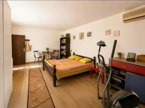 Namještena spavaća soba sa krevetom, radnim stolom i trenažerom. - image 7