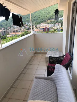 Natkriveni balkon sa garniturom za sjedenje i pogledom na naselje i brda. - image 2