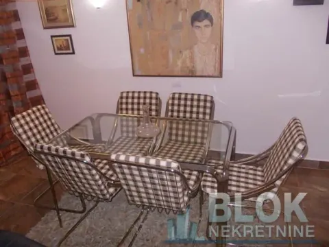 Dining area with a glass table and checkered chairs. - image 12