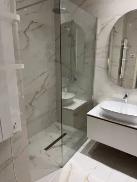 Modern bathroom with a shower cabin and a white sink. - image 8