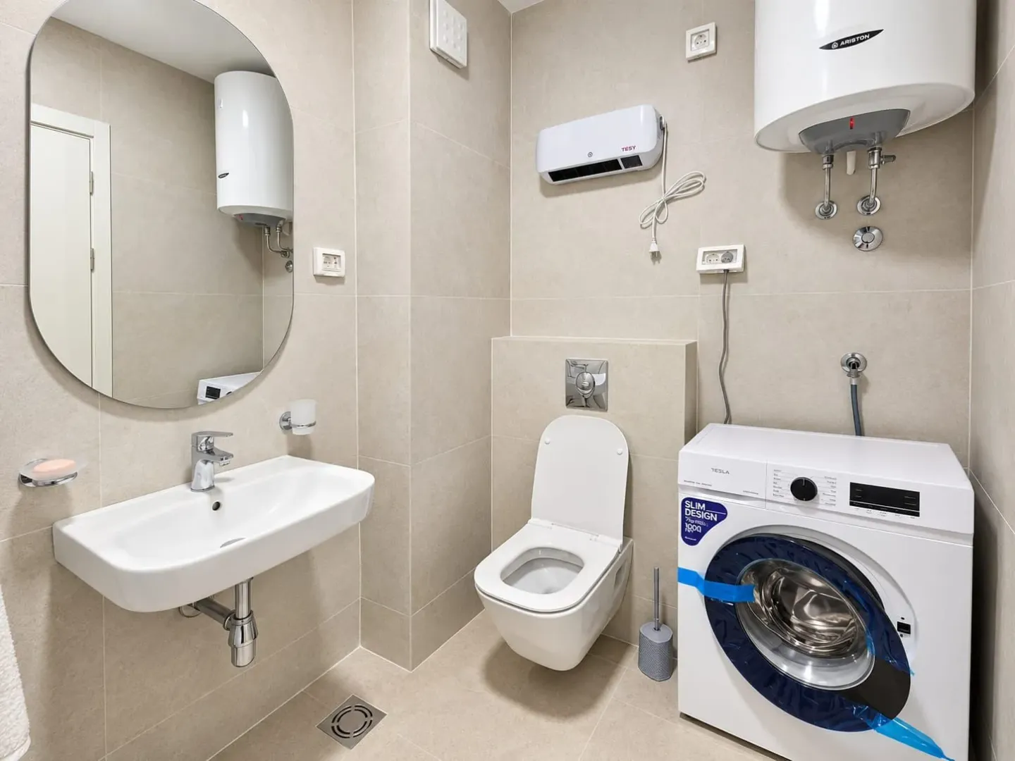 Modernly equipped bathroom with a washbasin, toilet, and washing machine.