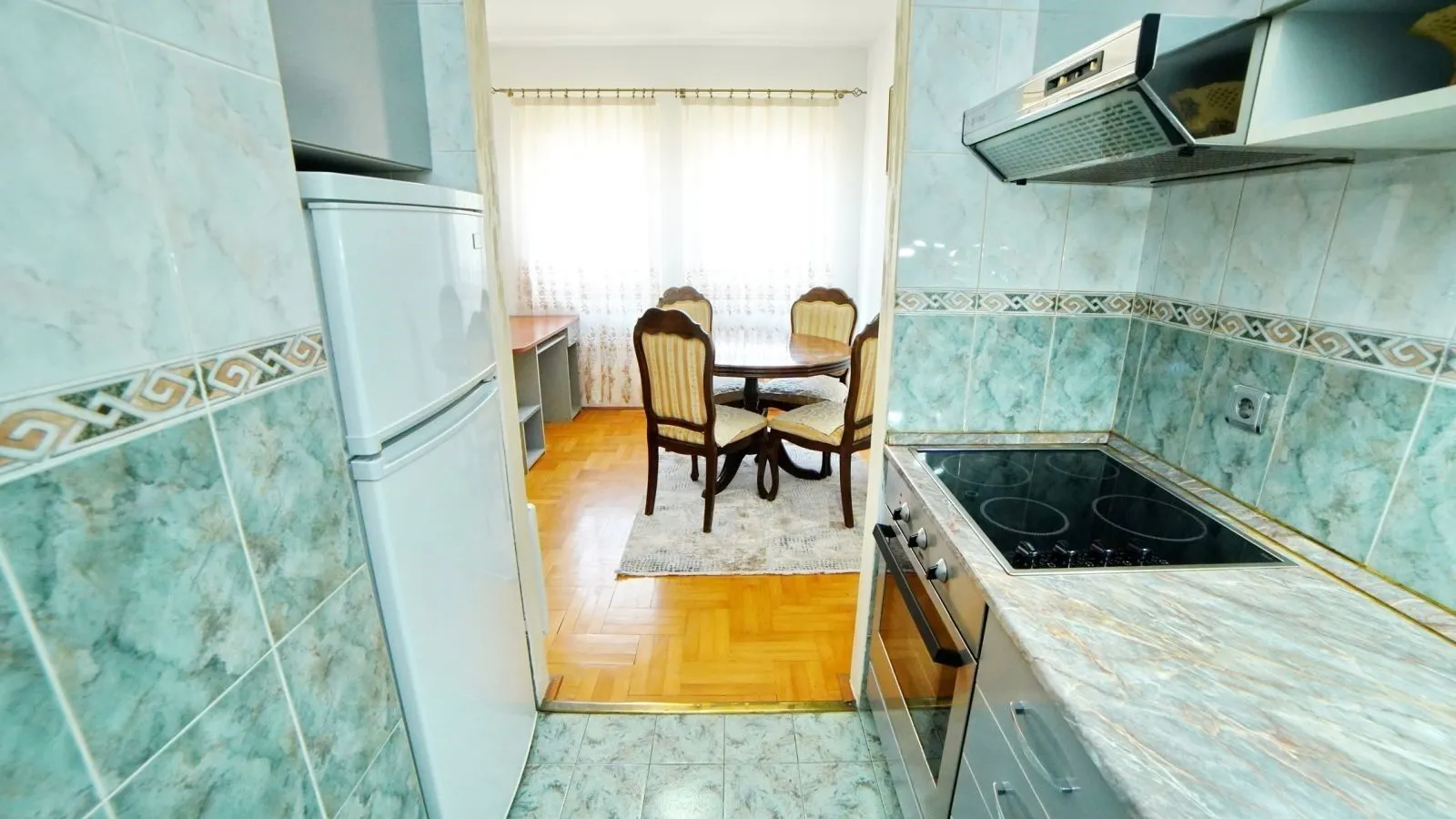 Kitchen with a view of the dining area featuring a table and chairs.