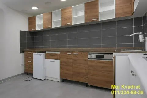 Kitchen with wooden cabinetry and dark tiles. - image 16