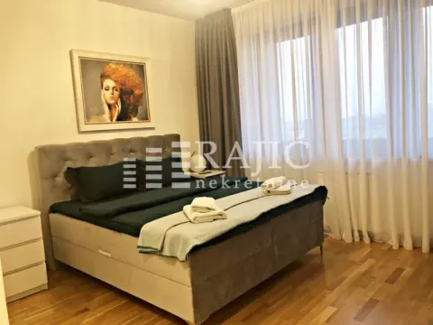 Furnished bedroom with a large double bed and a window with curtains. - image 5