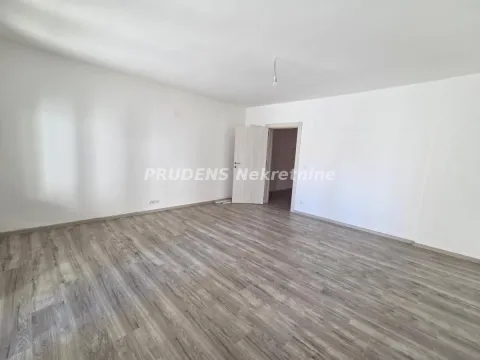 Prazna soba sa belim zidovima i laminatnim podom. - image 2