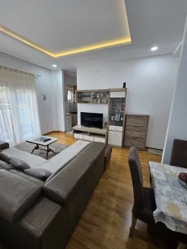 Living room with a sofa, TV unit, and dining table. - image 4