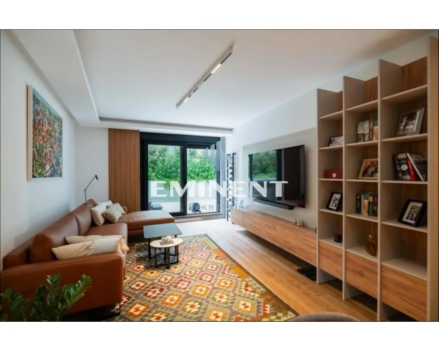 Modern living room with a sofa, TV, and a large bookshelf.