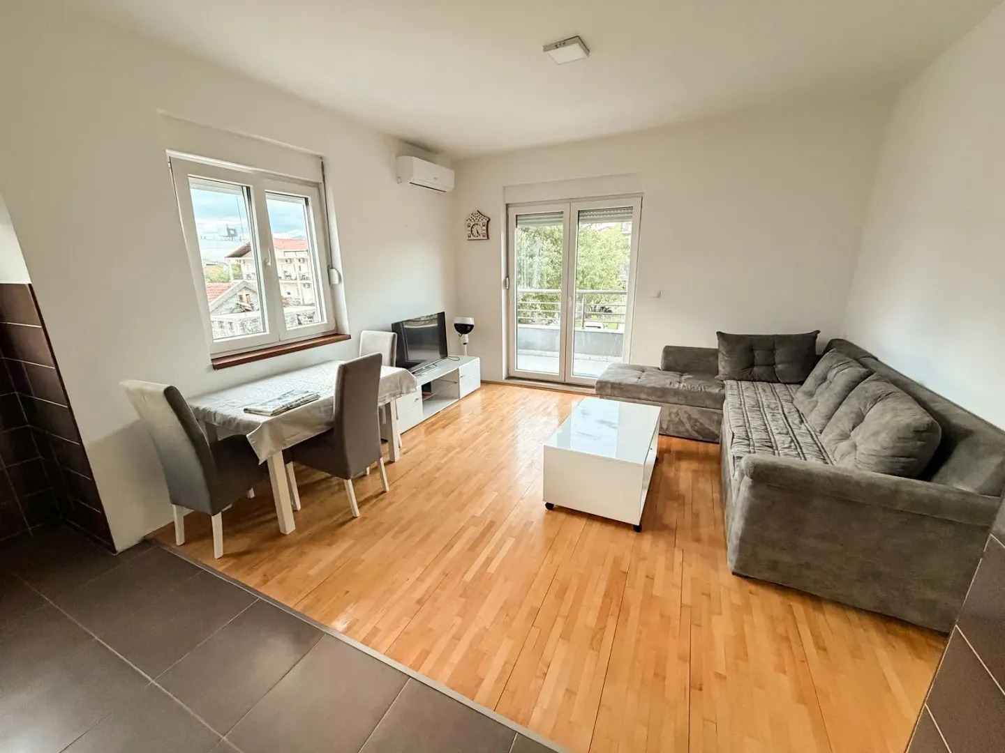 Living room with a sofa, dining table, and access to the terrace.