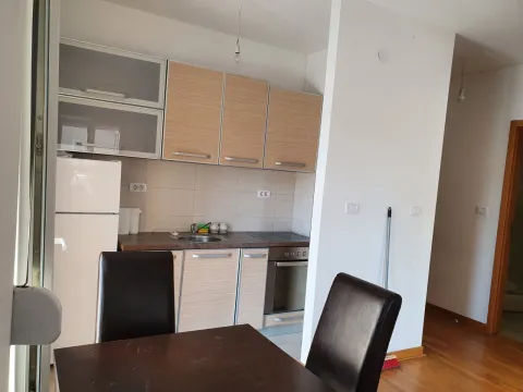 Jednostavna kuhinja sa svijetlim elementima i trpezarijskim stolom. - image 3
