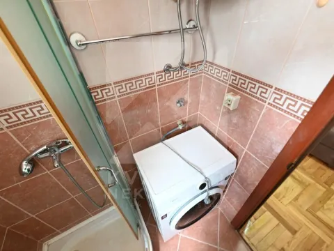 Bathroom with a shower cabin and washing machine. - image 5