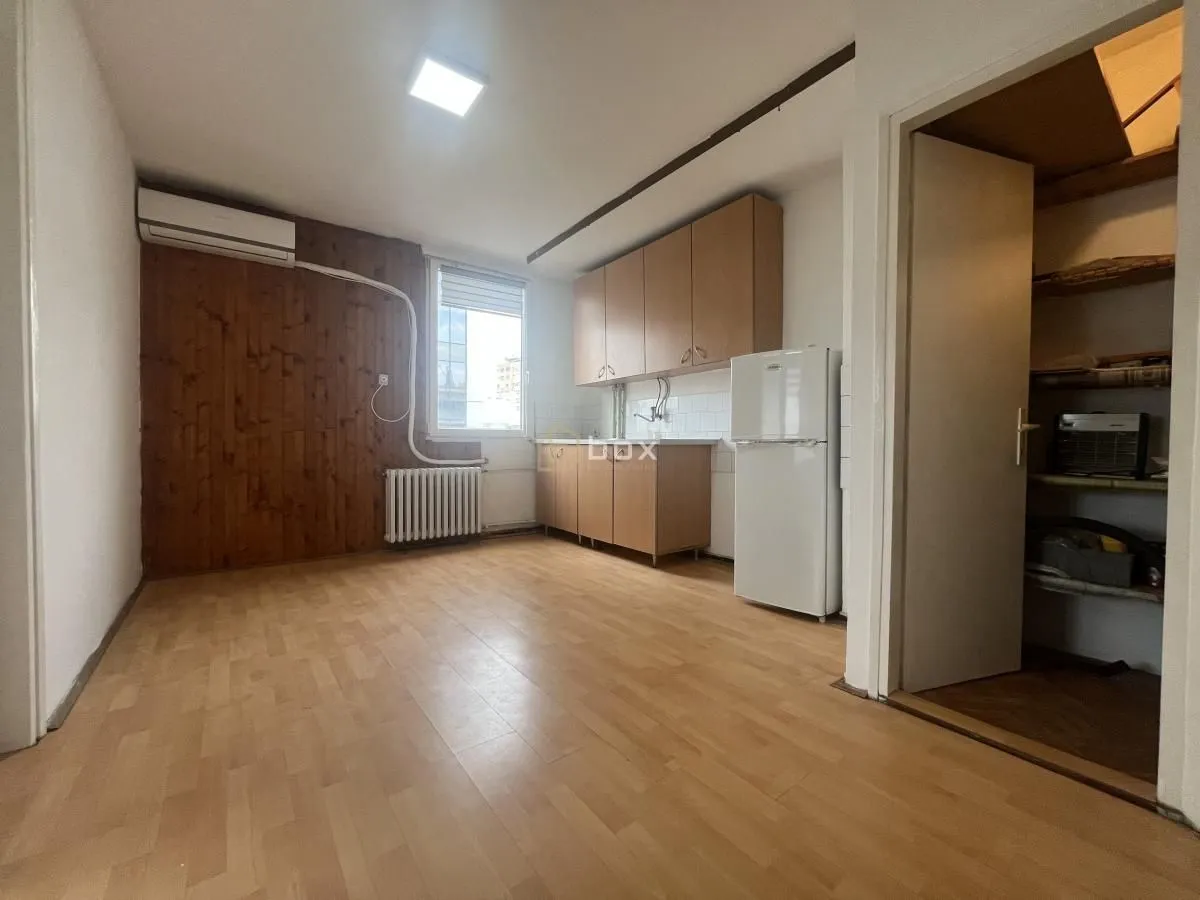 Smaller kitchen with wooden units and a refrigerator.