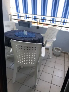Balkon sa stolom i bijelim plastičnim stolicama pod tendom. - image 11