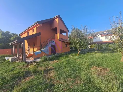Pogled na dvorište i fasadu dvospratne kuće narandžaste boje sa spoljnim stepeništem. - image 6
