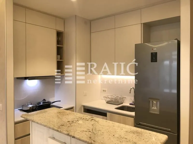 Modern kitchen with light cabinetry and a breakfast bar.