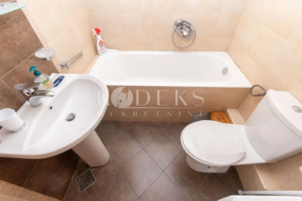 Small bathroom with a bathtub, washbasin, and toilet.