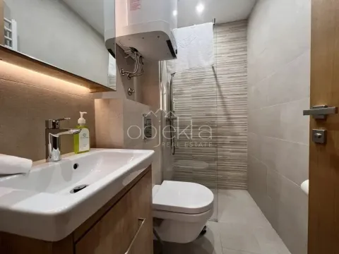 Modernly equipped bathroom with a washbasin, walk-in shower, and toilet. - image 11