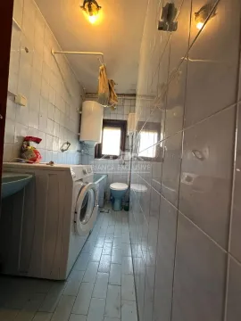 Manje kupatilo sa kadom, veš mašinom i belim pločicama. - image 11
