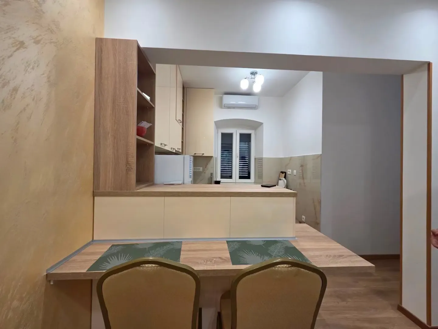 Smaller kitchen with a breakfast bar and dining table.