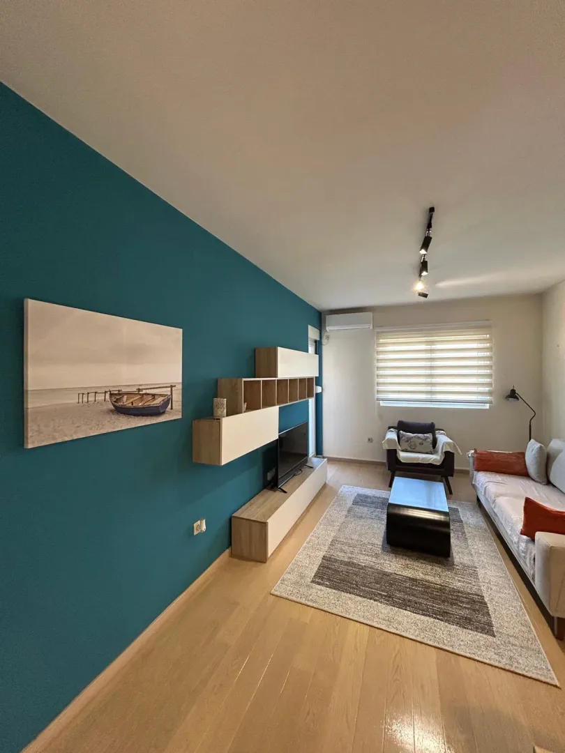 Living room with sofa, TV unit and blue wall.
