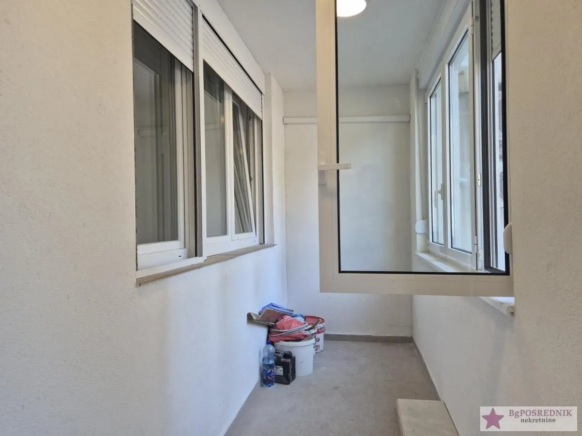 Glazed balcony with white walls and PVC windows.