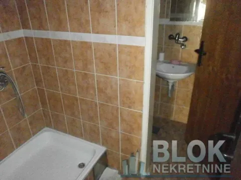 Small bathroom with a shower cabin and a washbasin, tiled with ceramic tiles. - image 4