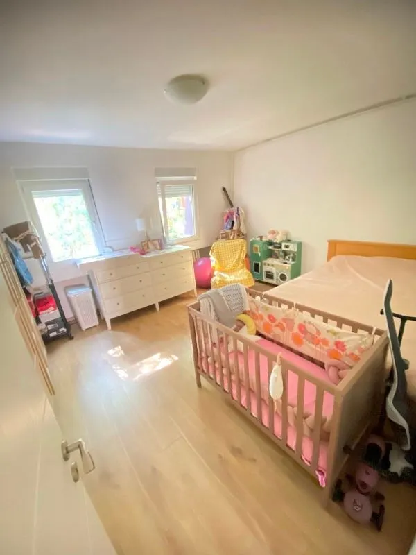 A bedroom with a double bed and a baby crib.