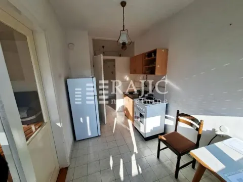 Smaller kitchen with a white refrigerator and wooden cabinets. - image 3