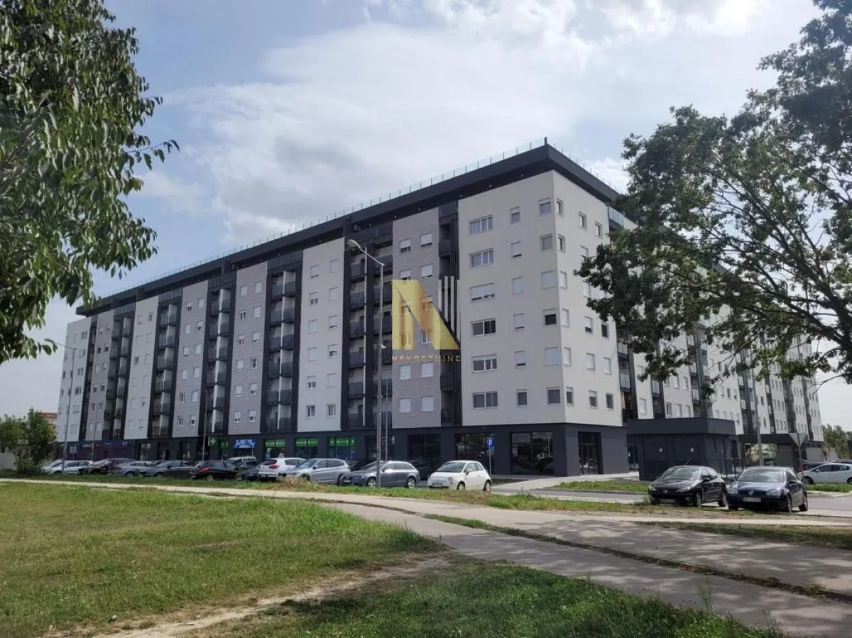 Exterior view of a modern multi-story residential building with parking.