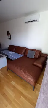 Living room with a leather sofa and air conditioning. - image 6