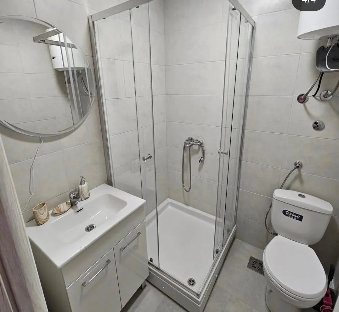 Small bathroom with a shower cabin, washbasin, and toilet.