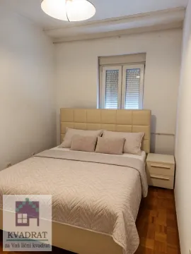 Spavaća soba sa bračnim krevetom i noćnim ormarićem. - image 6