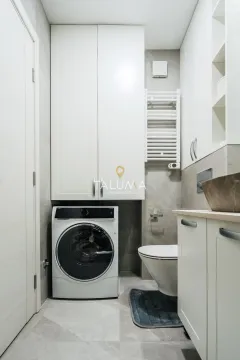 Moderno opremljeno kupatilo sa veš mašinom i ugradnim ormarićima. - image 9