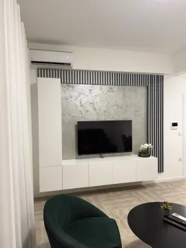 Living room with modern furniture, TV unit, and air conditioning. - image 3