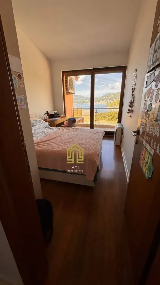 Manja spavaća soba sa bračnim krevetom i izlazom na terasu sa pogledom na more.