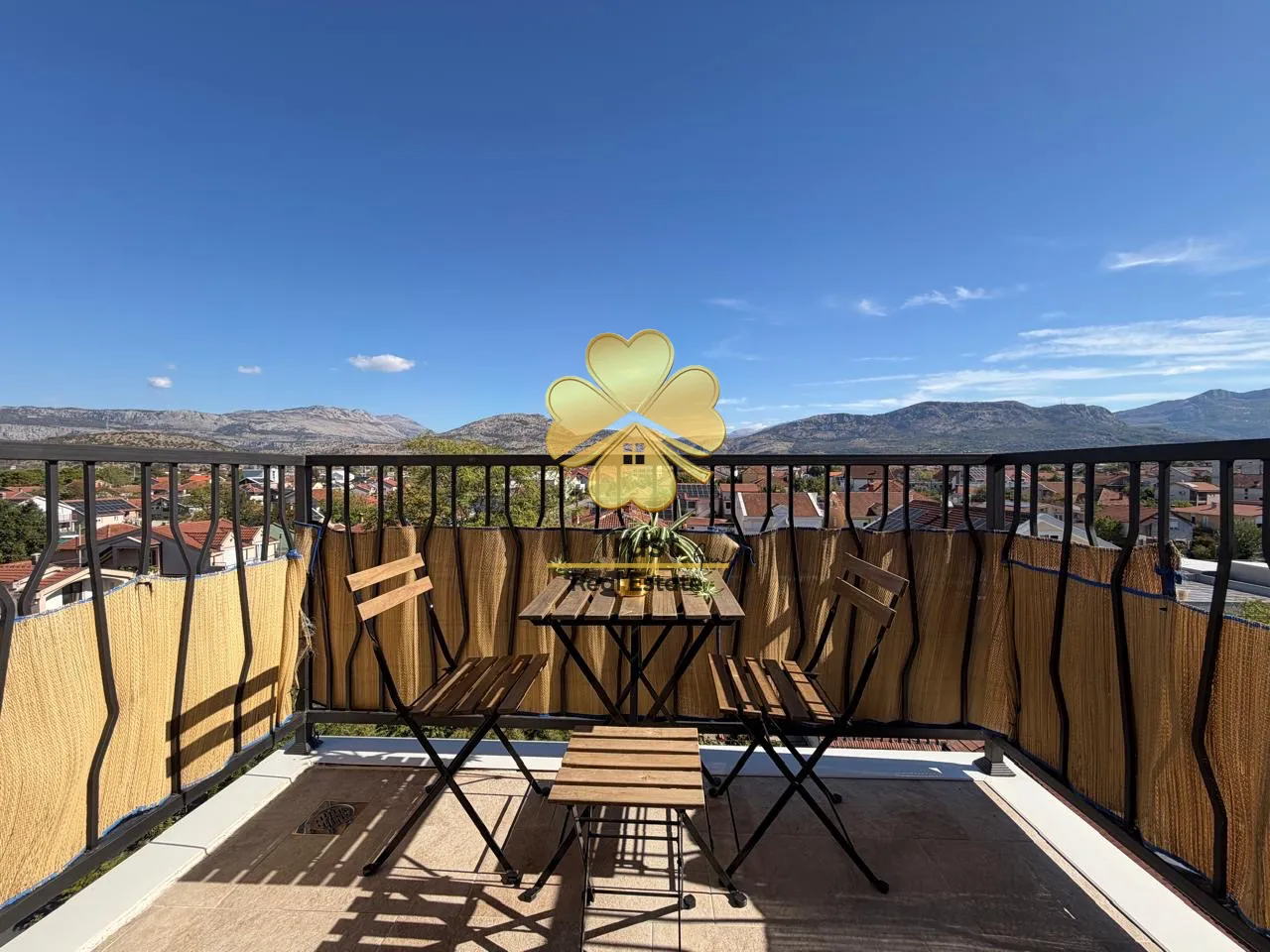 Furnished terrace with a table, chairs, and a view of the neighborhood.