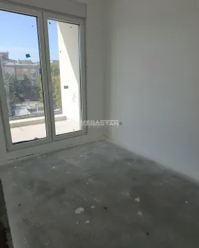 Prazna neuuređena prostorija sa balkonskim vratima i pogledom na okolinu. - image 7