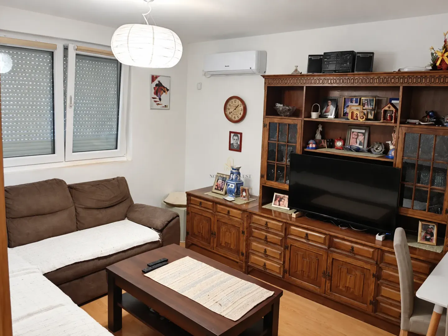 Living room with a sofa set, large wooden cabinet and TV.