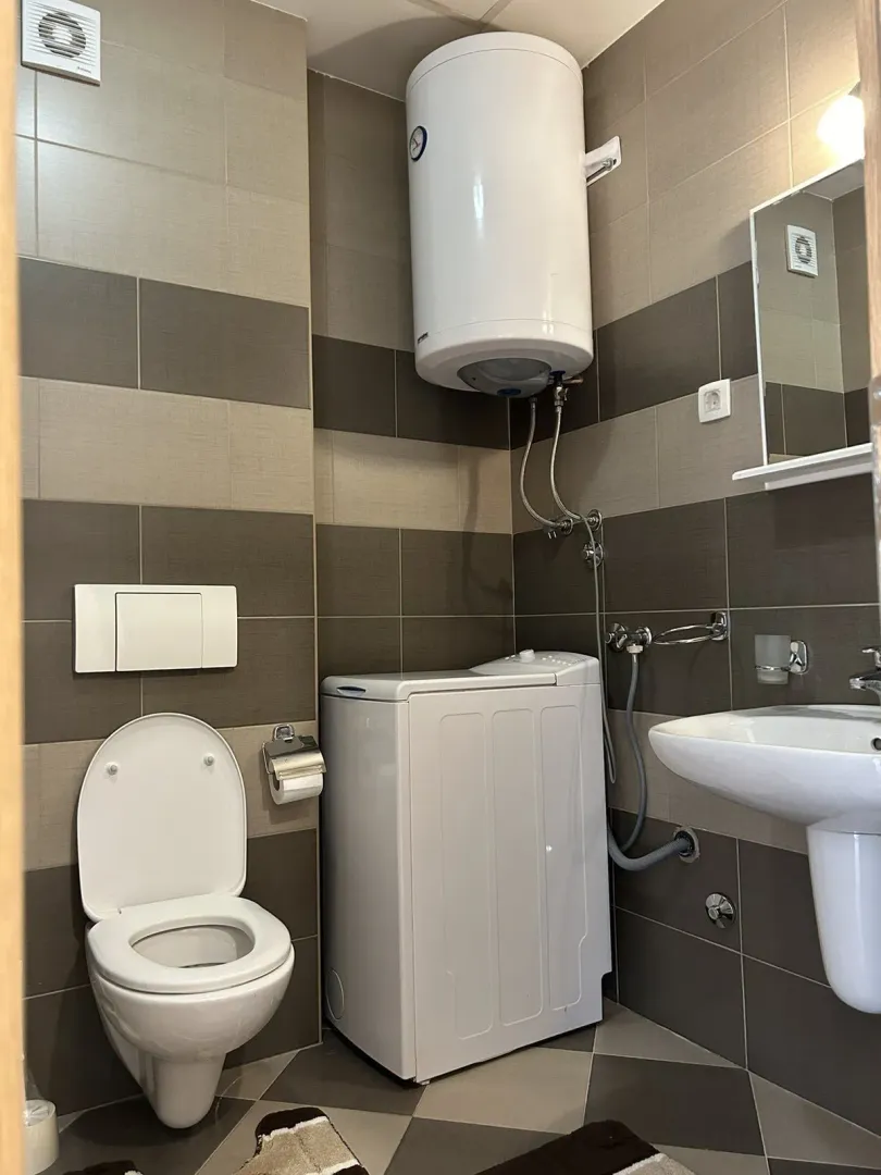 Kupatilo sa veš mašinom, bojlerom i wc šoljom.
