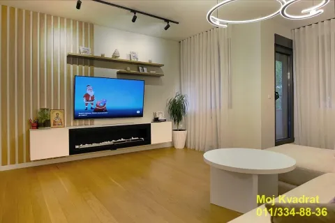 Modernly furnished living room with a TV and decorative lighting. - image 2